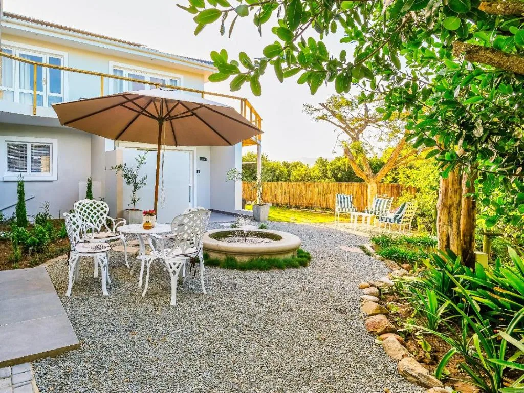 Spacious garden patio with umbrella, seating, and fire pit