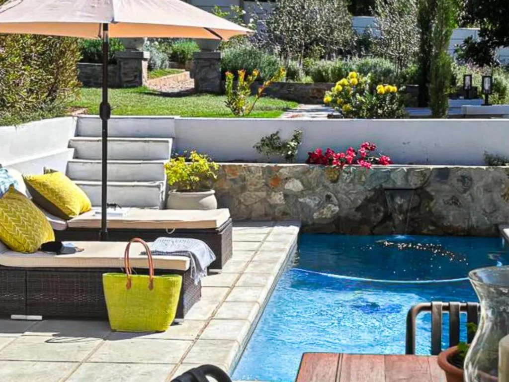 Swimming pool with stone surround and tiered garden landscaping beyond