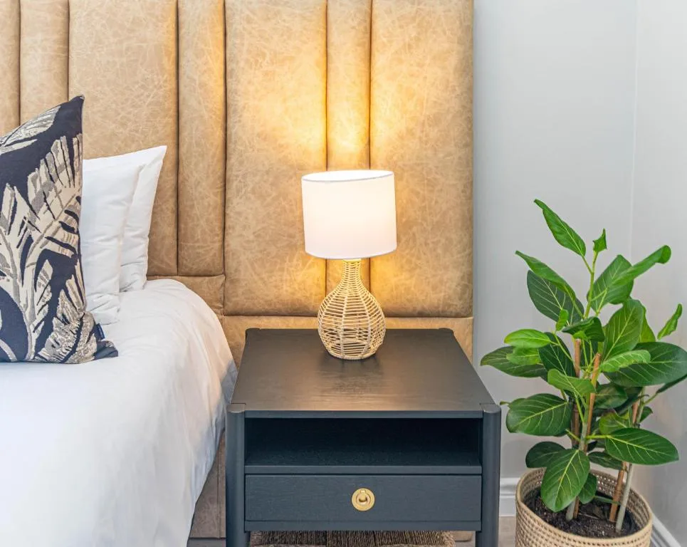 Bedroom bedside table with woven lamp and potted plant decoration