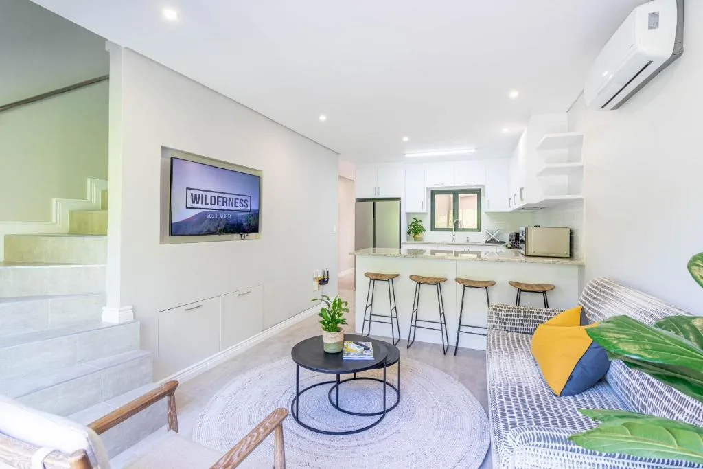 Modern living room with TV, kitchen counter seating, and contemporary decor