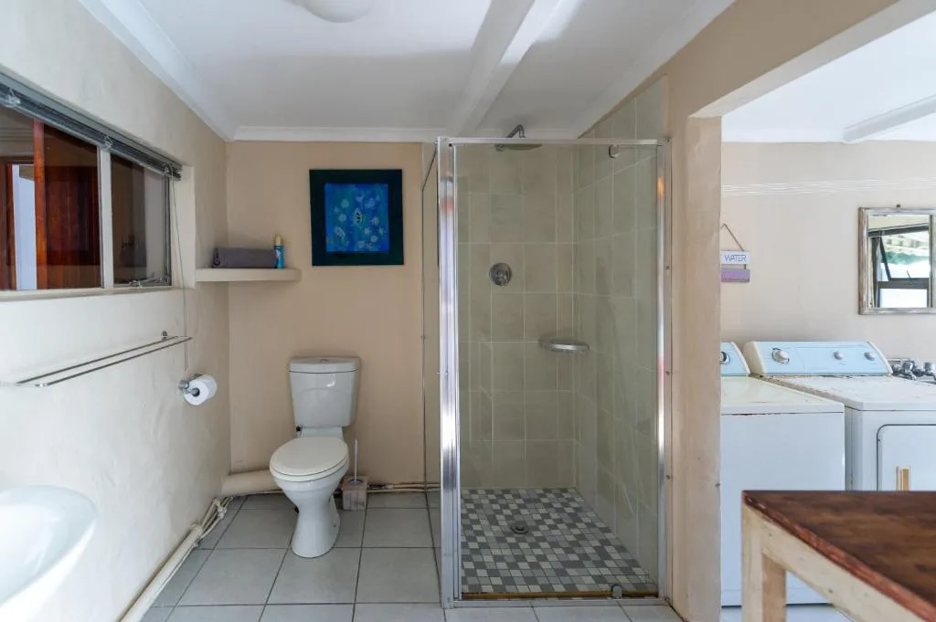 Spacious bathroom with walk-in shower, toilet, and tiled flooring throughout