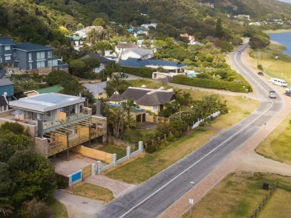 Aerial view of property nestled in lush valley with lagoon visible