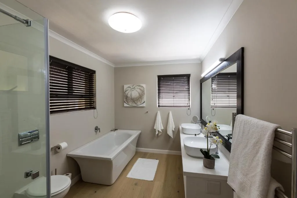 Modern bathroom with freestanding bath, dual vanity, and shower enclosure