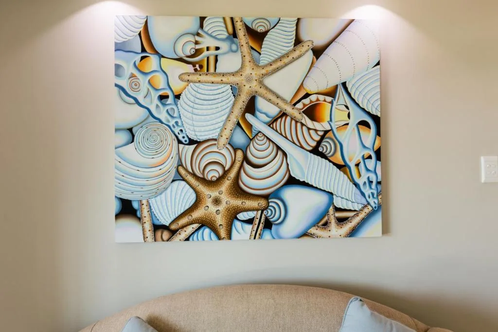 Decorative coastal artwork featuring starfish and shells on bedroom wall