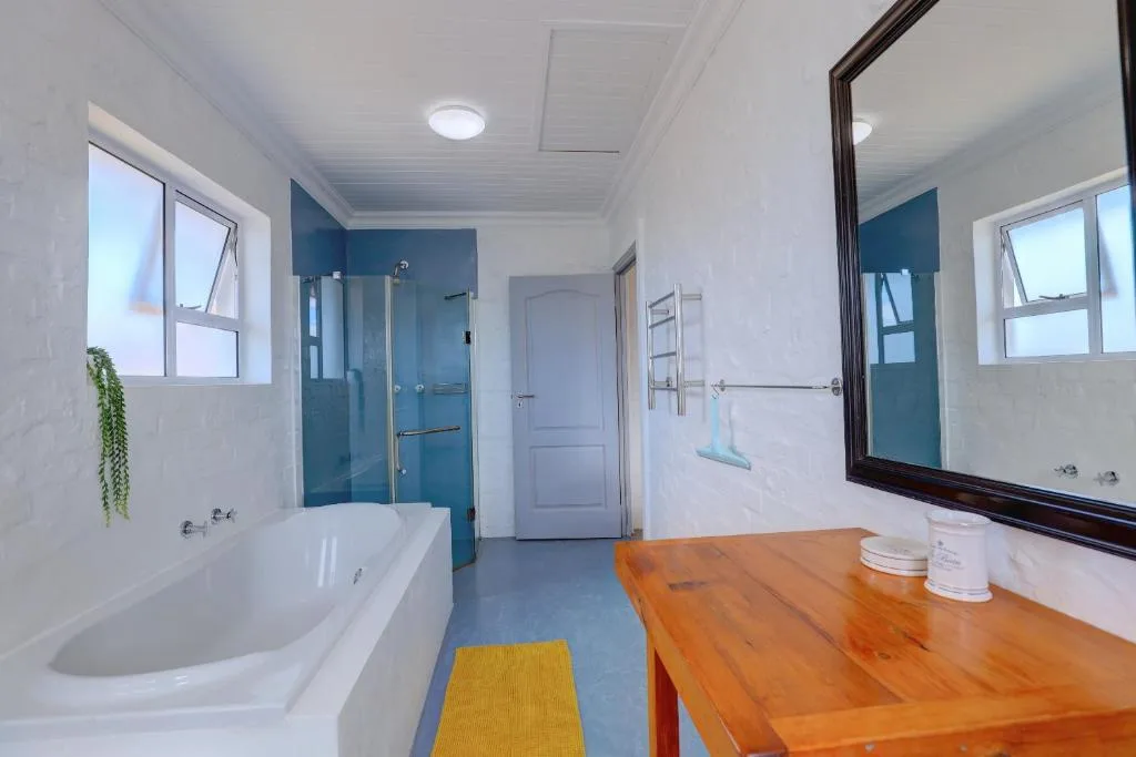 Modern bathroom with bathtub, glass shower enclosure, wooden vanity, and large mirror