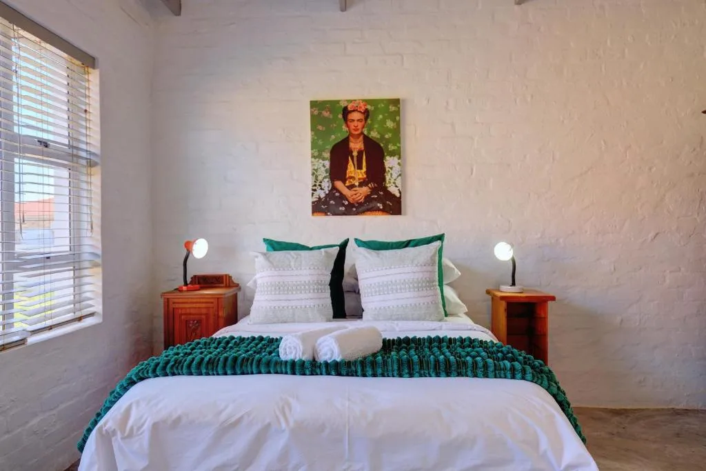 Bright bedroom with white linens, teal accents, wooden bedside tables