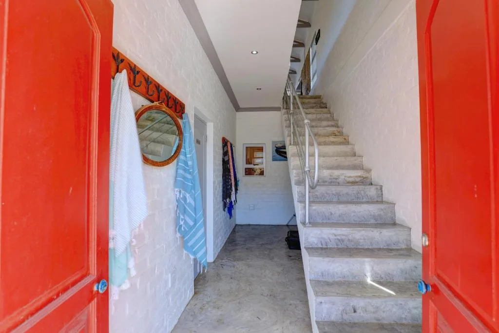 Bright red doors frame interior entryway with stone staircase leading upward