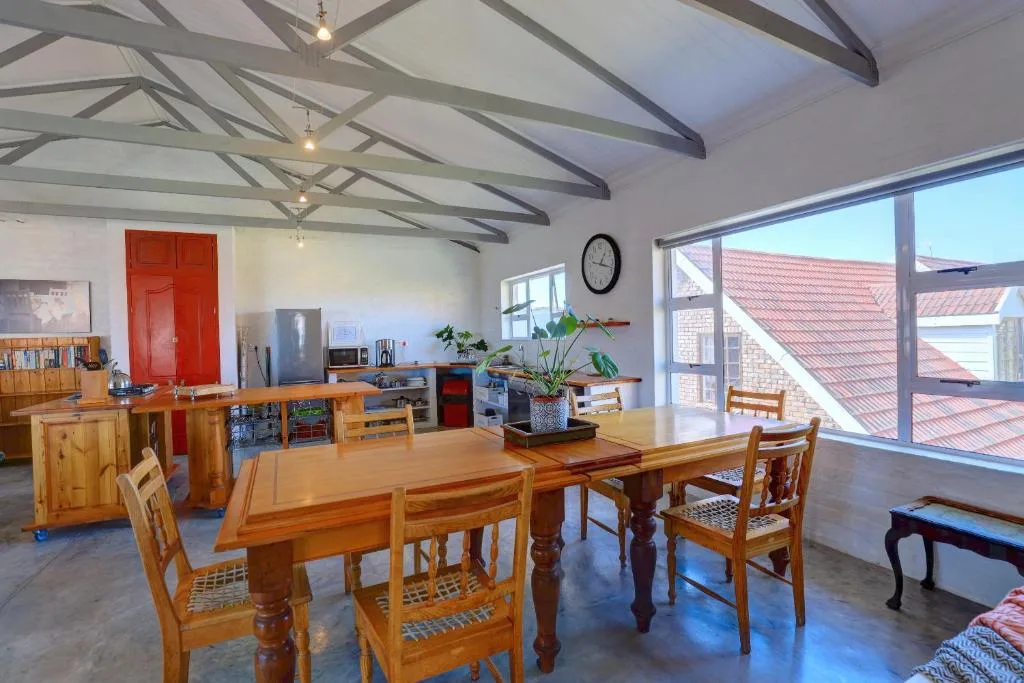 Open-plan dining and kitchen area with wooden table and exposed beam ceiling