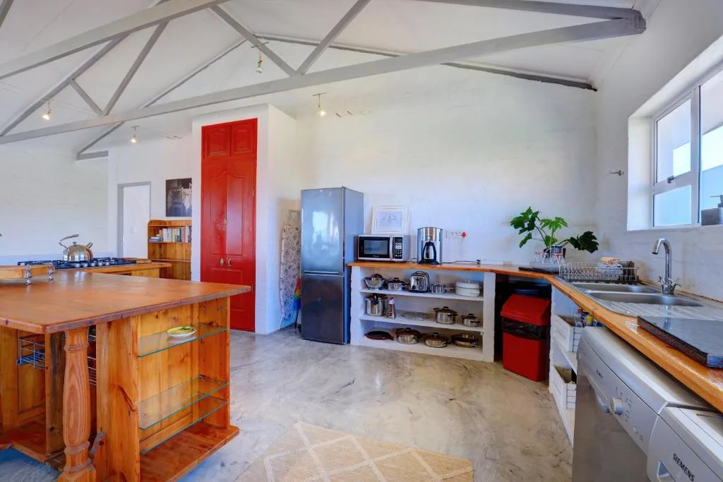 Spacious open-plan kitchen with wooden island, red accents, and modern appliances