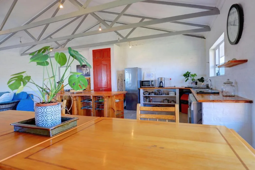 Open-plan kitchen with wooden counters, stainless steel fridge, and exposed beams