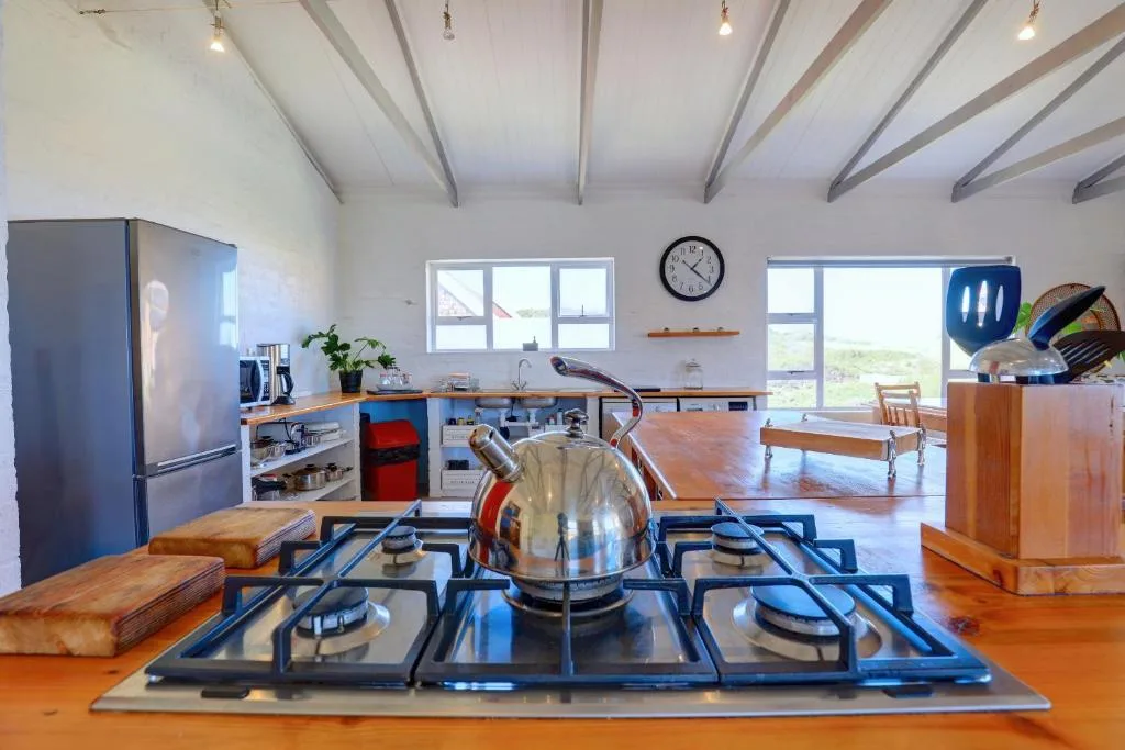 Modern kitchen with gas cooktop, stainless steel appliances, wooden counters