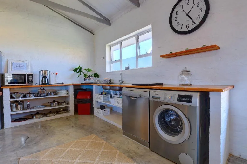 Modern kitchen with stainless steel appliances, wooden counters, open shelving