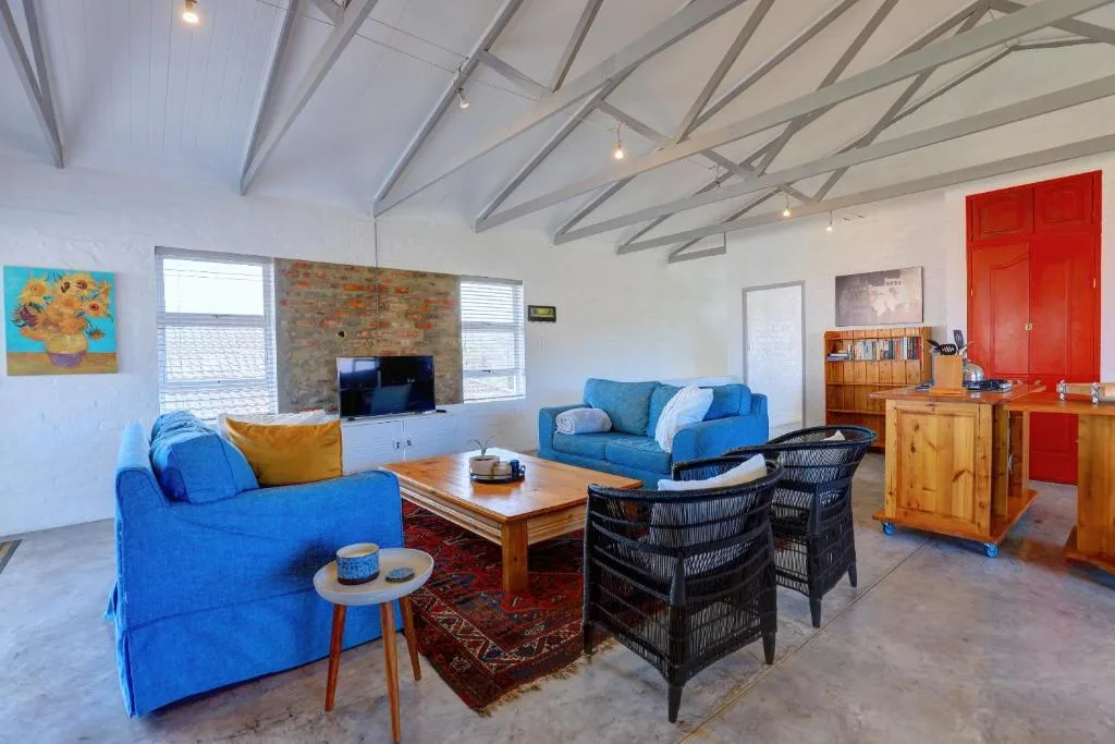 Spacious lounge with blue sofas, fireplace, and high vaulted ceilings