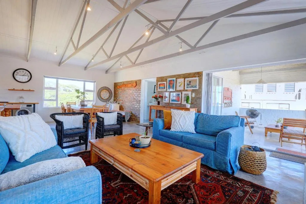 Bright open-plan lounge with blue sofas, wooden coffee table, and exposed beams