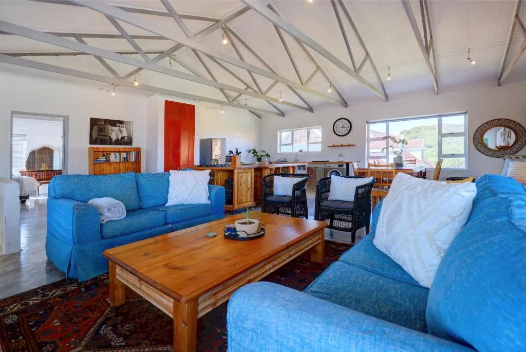 Spacious open-plan lounge with blue sofas and wooden coffee table