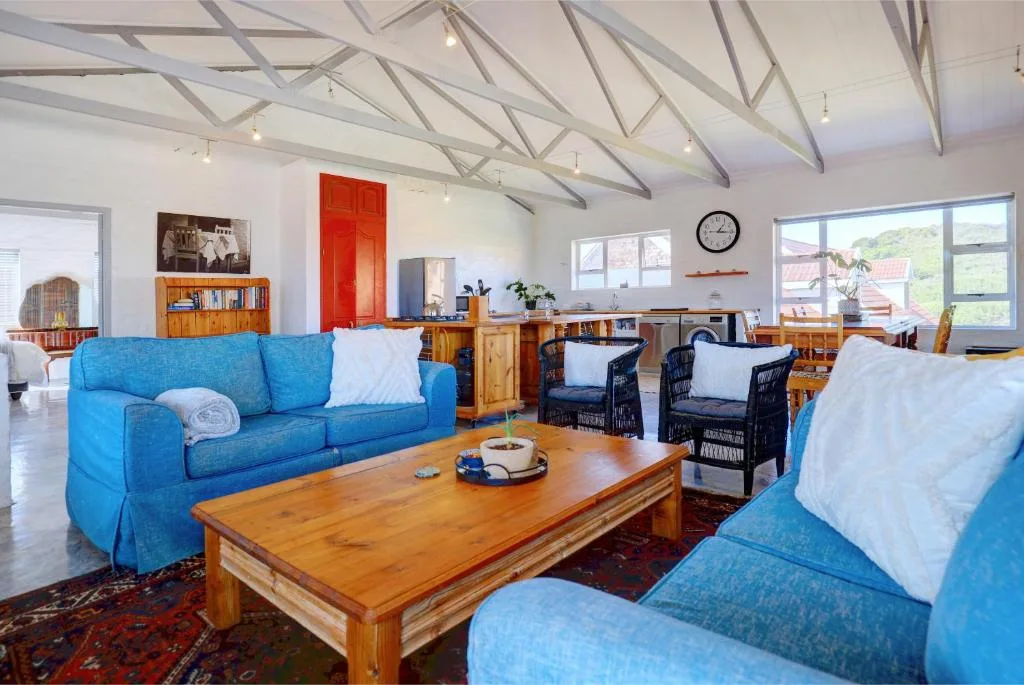 Spacious lounge with blue sofas, wooden coffee table, and vaulted ceiling