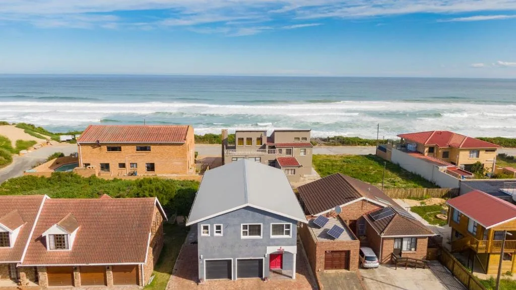Beachfront property with ocean waves and sandy coastline in background