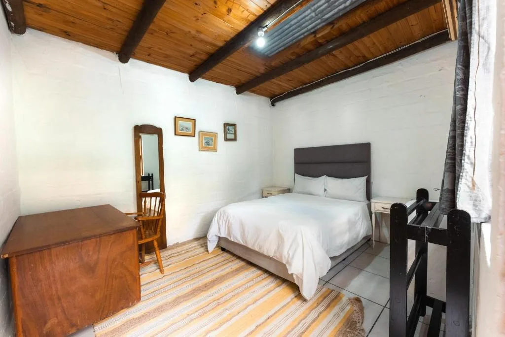 Spacious bedroom with queen bed, wooden beams, and rustic decor accents
