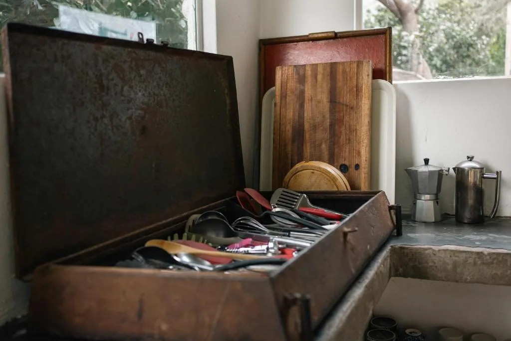 Vintage kitchen utensils and cooking tools displayed on windowsill