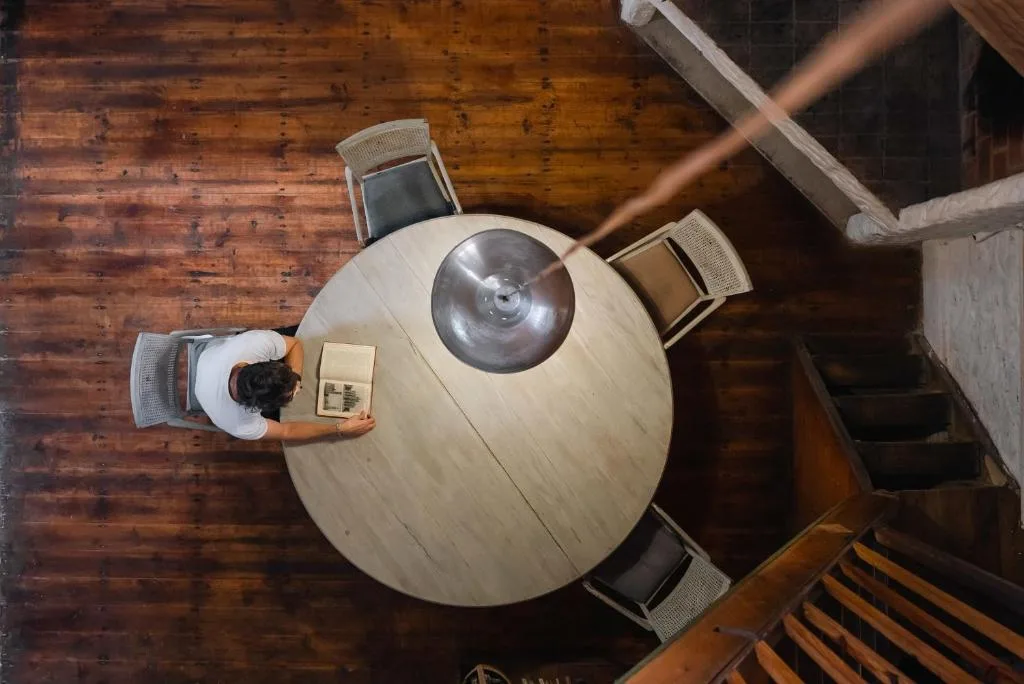 Overhead view of round dining table with four chairs and wooden flooring