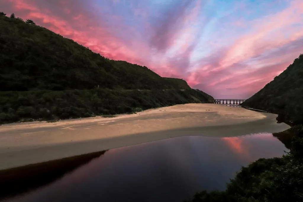 Stunning sunset over Kaaimans River estuary with dramatic pink sky and cliffs