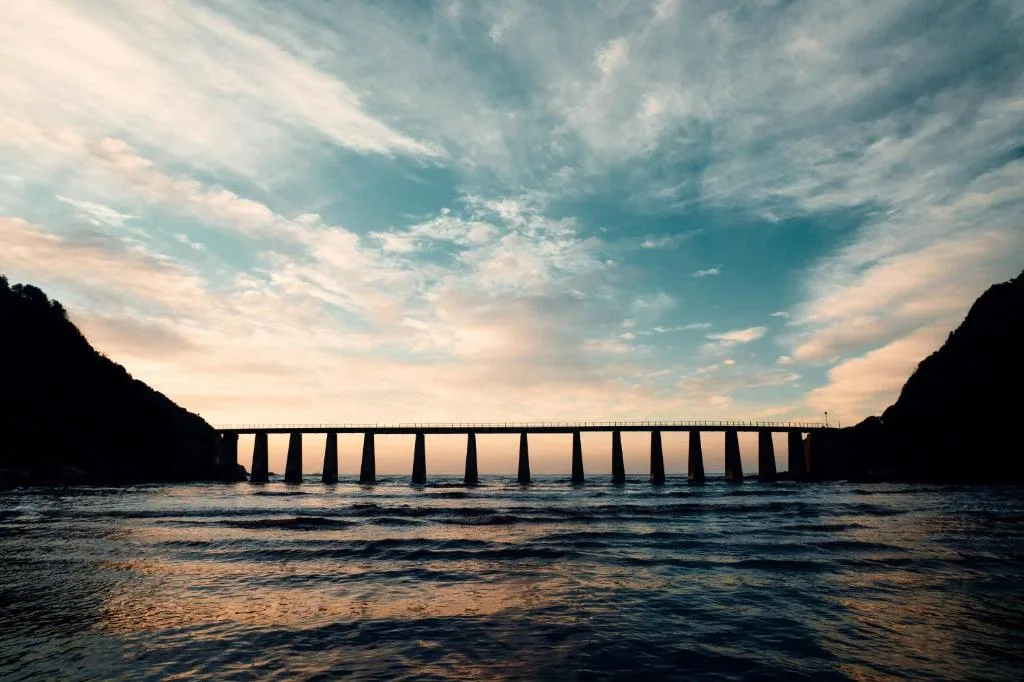 Scenic coastal view of bridge spanning Kaaimans River at sunset