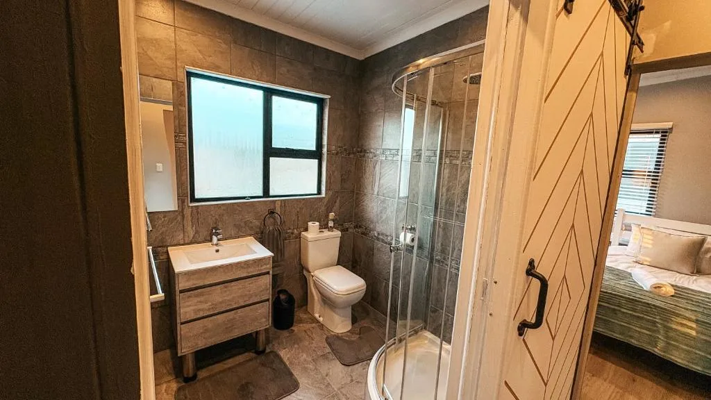 Modern bathroom with walk-in shower, vanity sink, and toilet fixtures