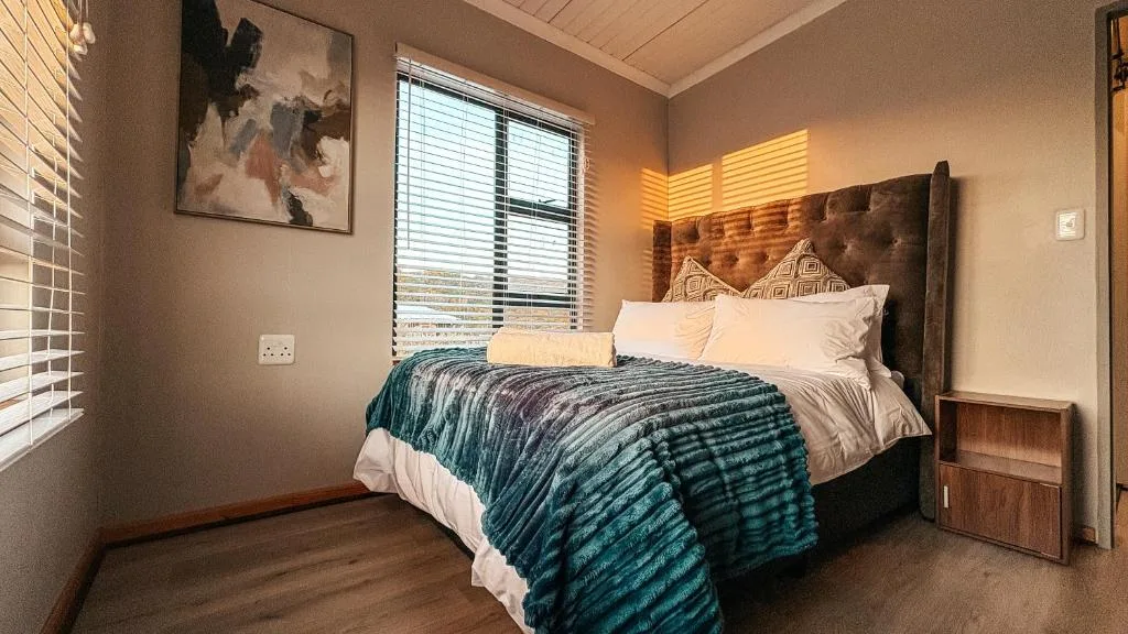 Spacious bedroom with upholstered headboard bed and natural light
