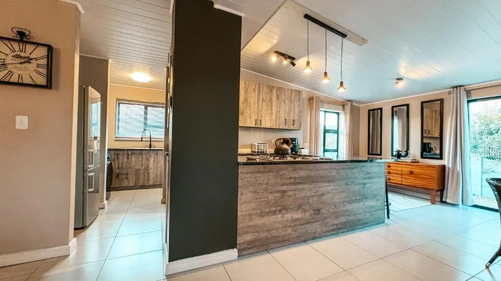 Modern open-plan kitchen with wooden cabinetry and pendant lighting fixtures
