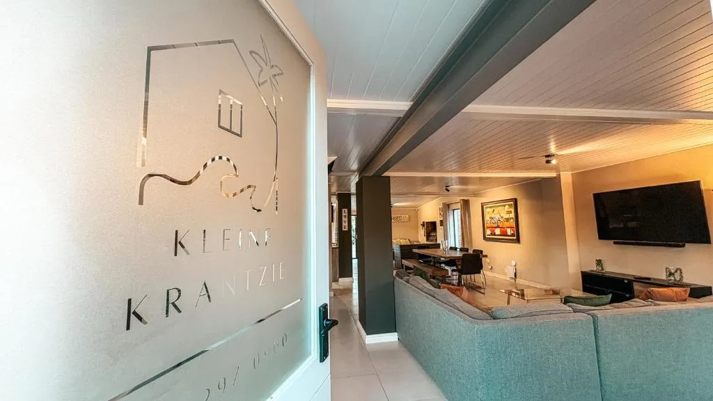 Modern lounge with turquoise sofa, wall-mounted TV, and warm lighting