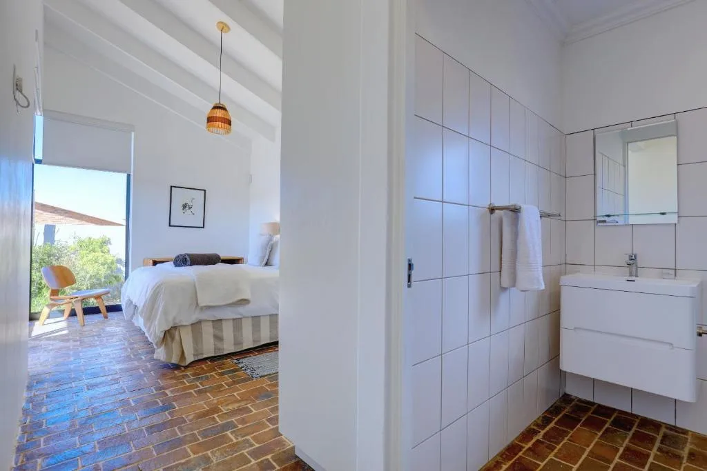 Modern white bathroom with tiled walls, vanity sink, and clean finishes