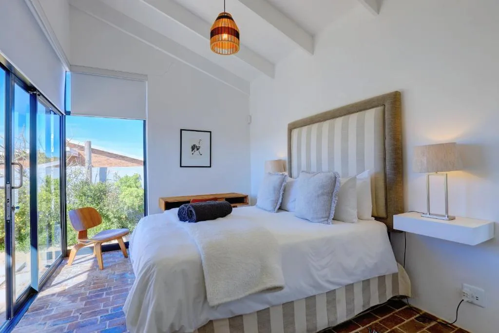 Bright modern bedroom with twin beds, mountain views through large sliding doors