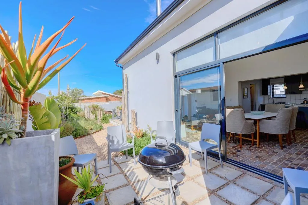 Outdoor patio with braai, potted plants, and lounge seating area