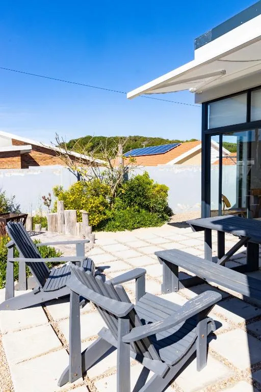 Outdoor patio with wooden loungers and modern house architecture