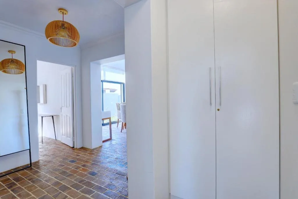 Modern hallway with white wardrobes and wooden pendant lights