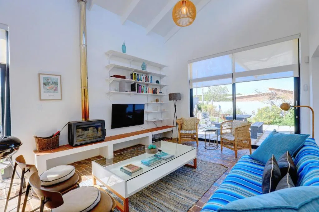 Bright lounge with blue striped sofa, TV, and scenic window views