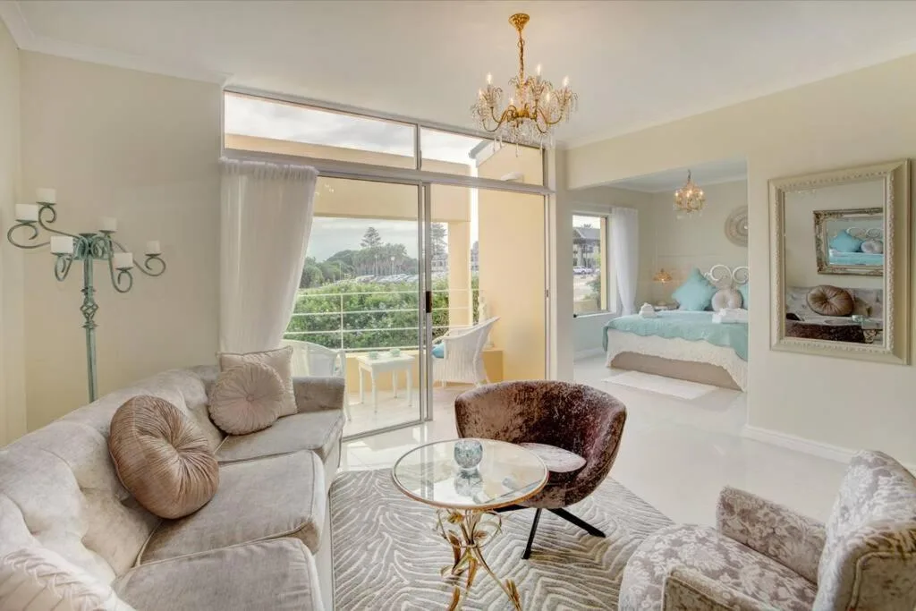 Bright lounge with cream sofa, round glass table, and scenic mountain views through large sliding doors