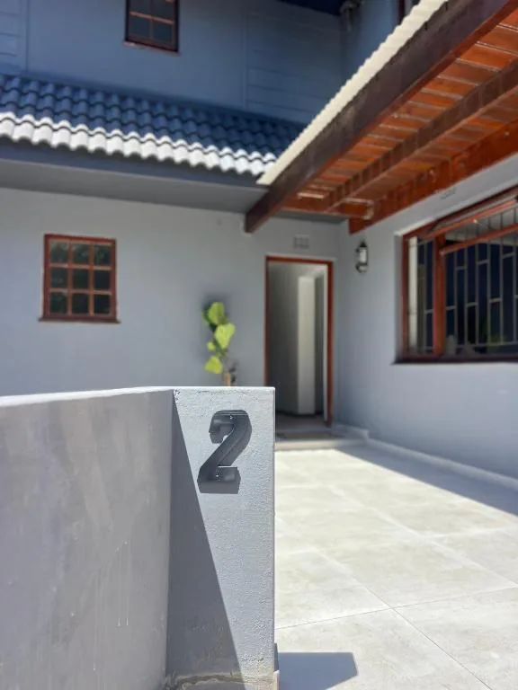 Modern whitewashed cottage exterior with number two marker and wooden beams