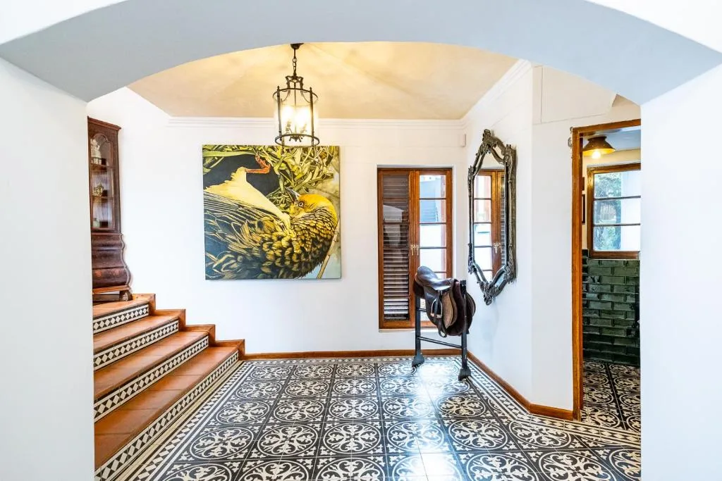 Elegant entrance hall with ornate tile floor and wooden staircase