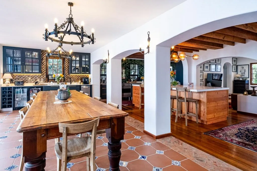 Spacious dining room with wooden table, blue cabinetry, and arched ceilings