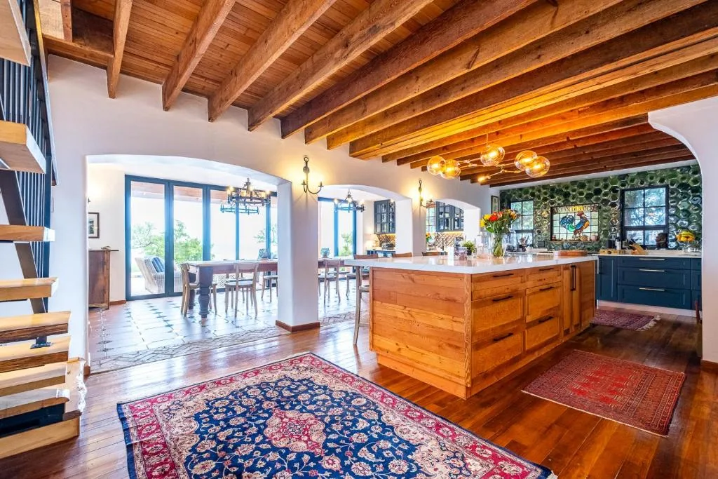 Open-plan kitchen with wooden beams, island counter, and dining area