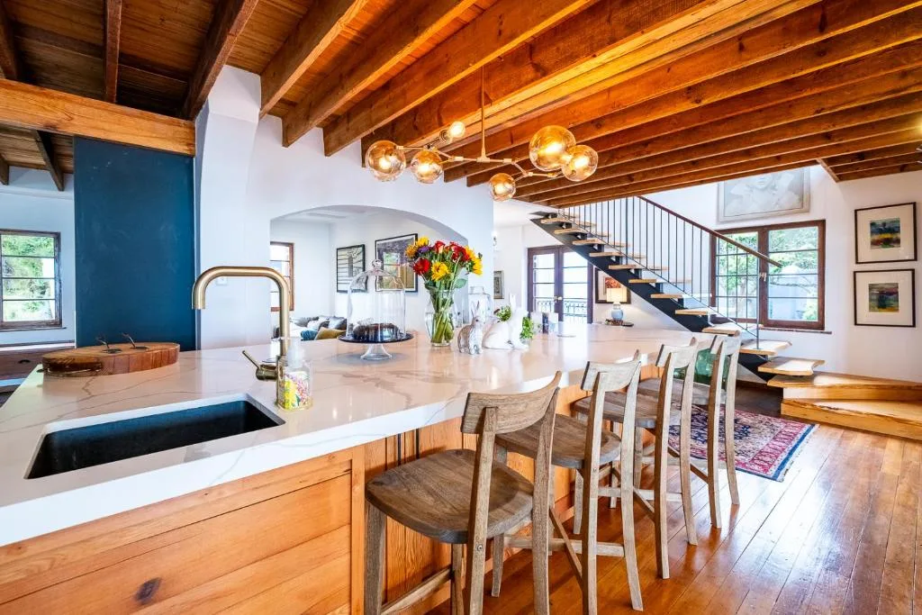 Modern open-plan kitchen with island bench and dining chairs