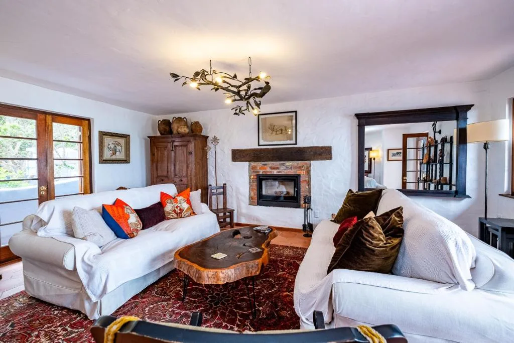 Spacious living room with white sofas, fireplace, and decorative lighting fixture