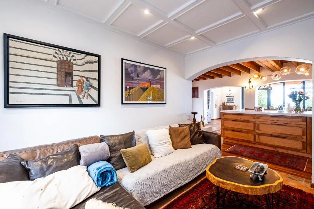 Spacious living room with leather sofa, wooden furniture, and framed artwork