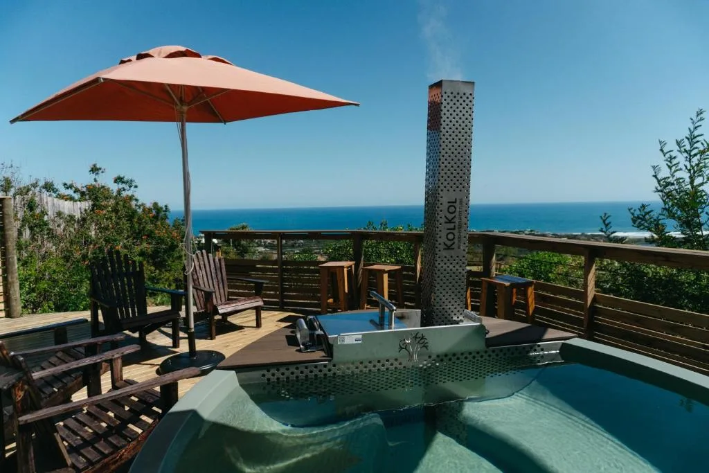 Oceanview deck with umbrella, seating, and scenic coastal horizon