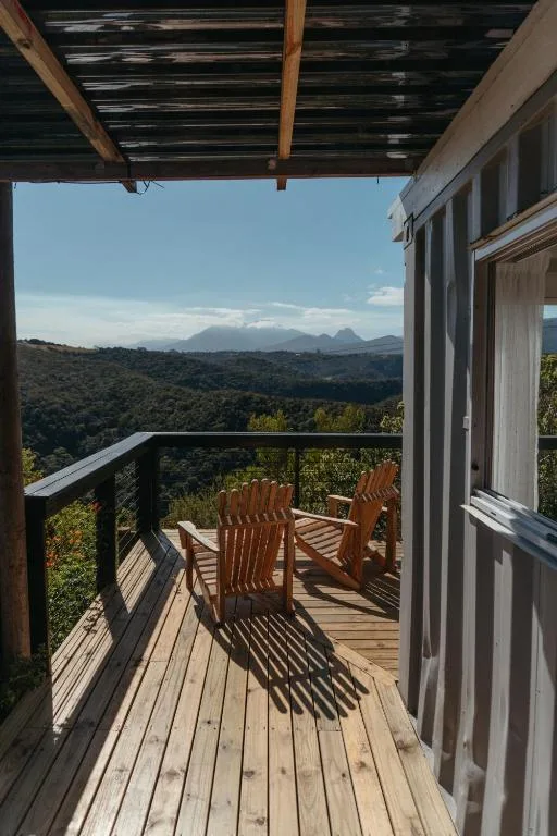 Wooden deck with Adirondack chairs overlooking mountain landscape views