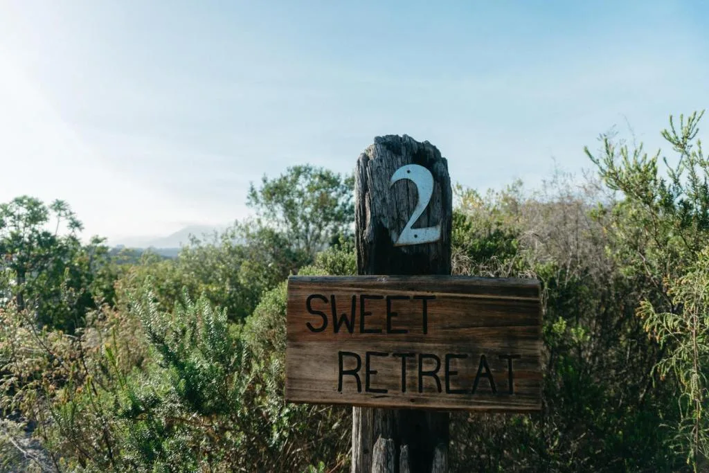 Wooden property sign reading Sweet Retreat with number two marker