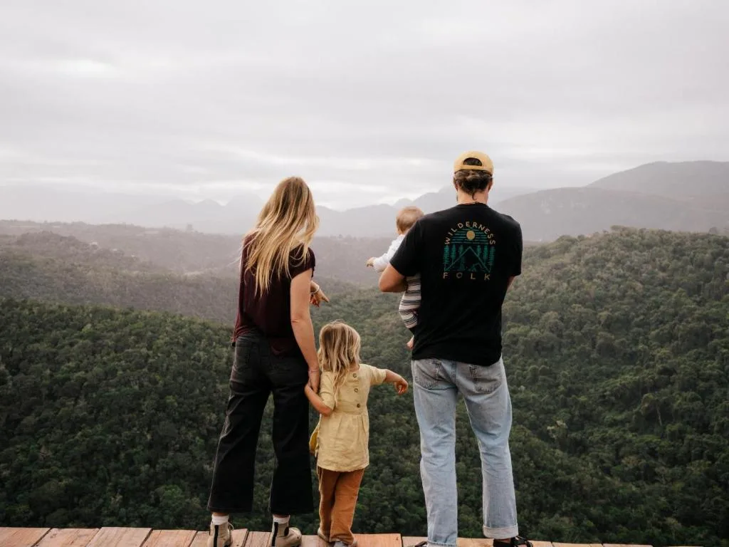 Family enjoying expansive forested valley and mountain views from deck