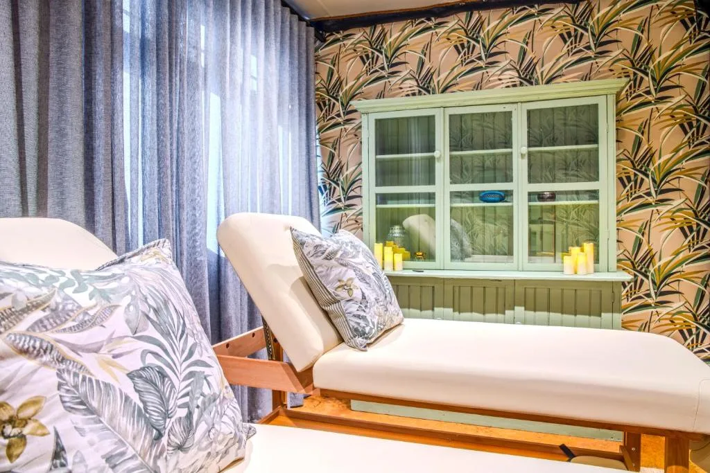 Bedroom with bed, daybed, botanical wallpaper, and large windows