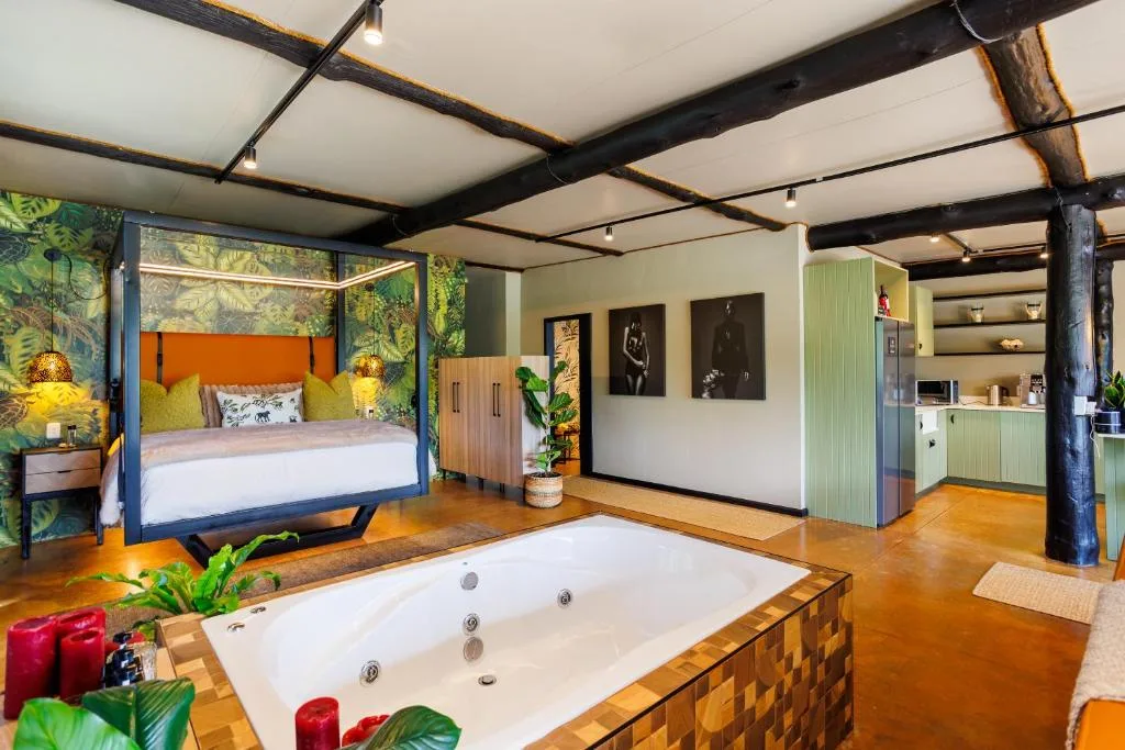 Luxurious bedroom with four-poster bed, spa bath, and tropical decor